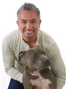 Cesar Millan holding a pit bull