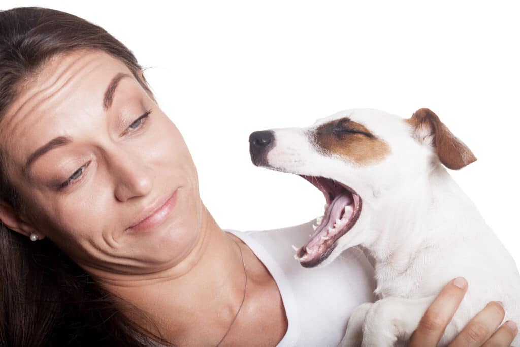 A woman experiences her dog's bad breath.