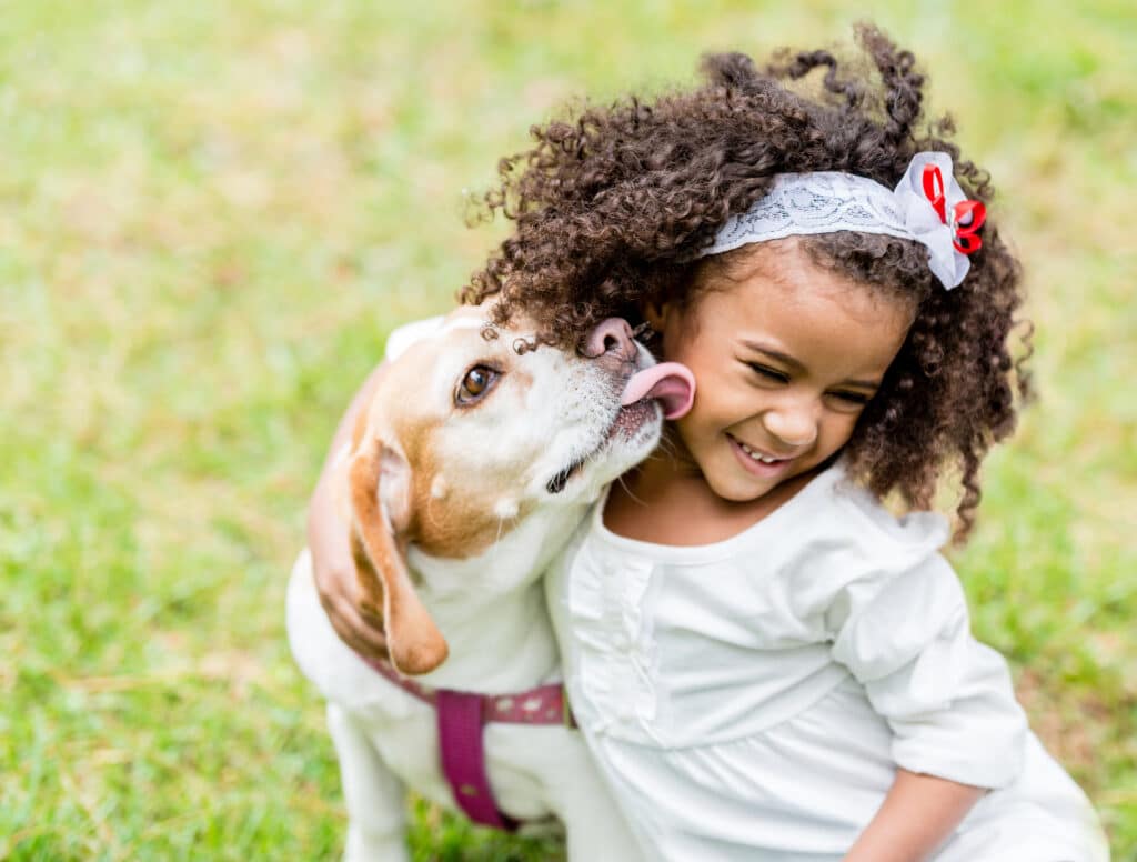 dog licks young girl's face