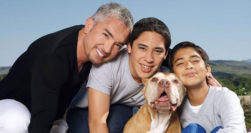 Cesar Millan poses with his two sons and their family pet