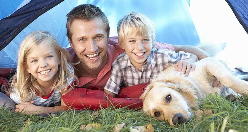 A family camps with their dog.