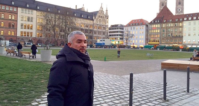 Cesar Millan poses at a park while on a walk.