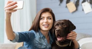 A woman poses with her chocolate lab.